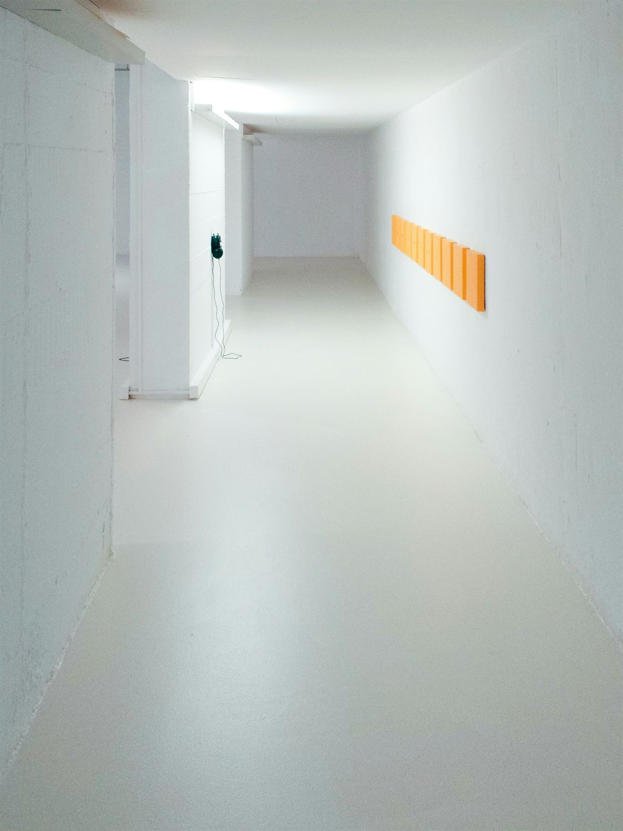 A long, bright, empty white corridor