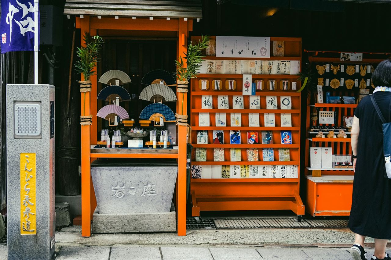 A small wooden shrine stall with rows of omamori charms on display