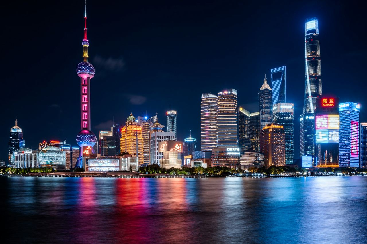 Pudong’s towers lit up at night, reflected in the river
