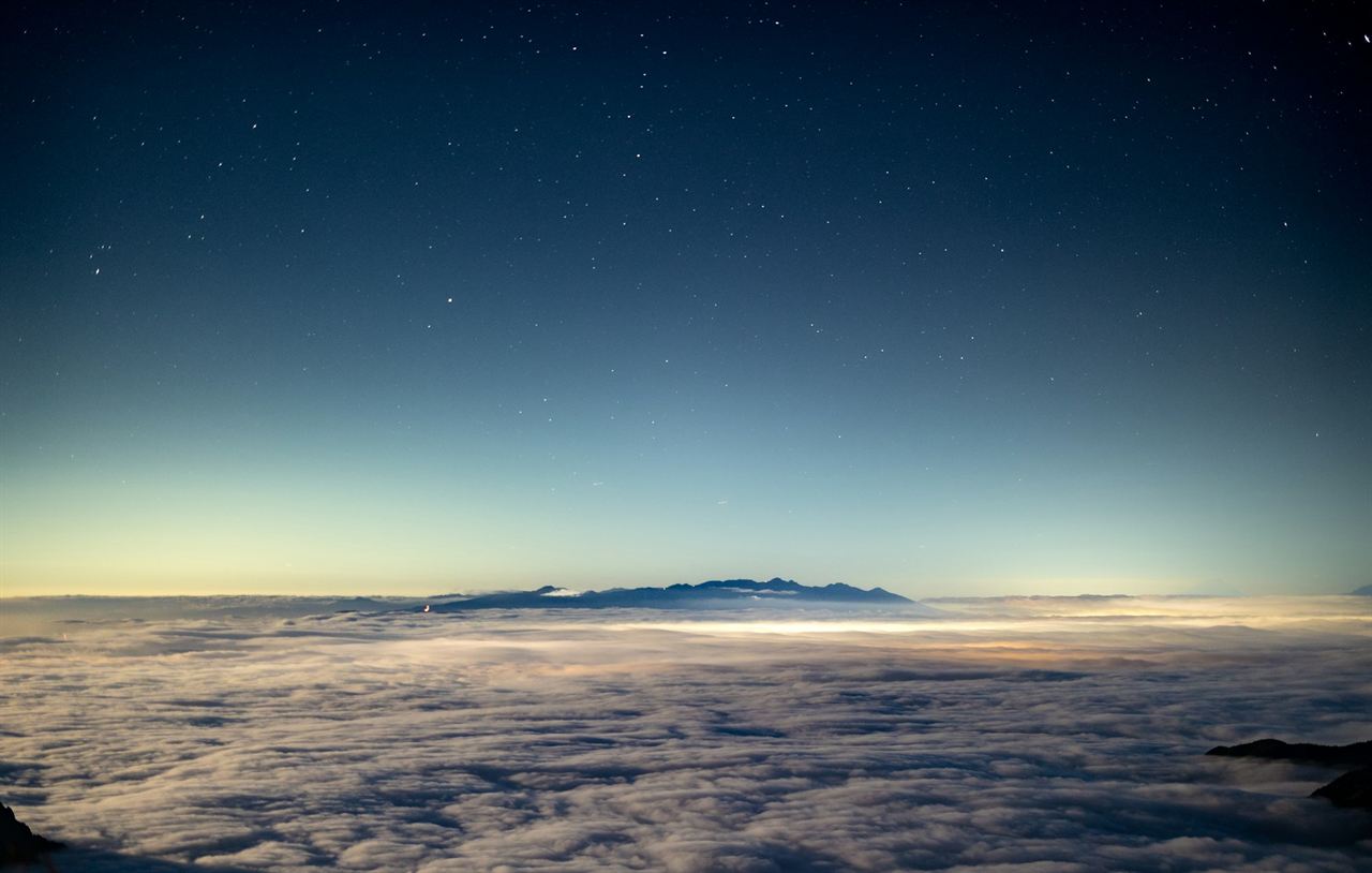 Stars above a sea of clouds at night